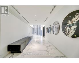 A hallway with a bench and pictures on the wall.
