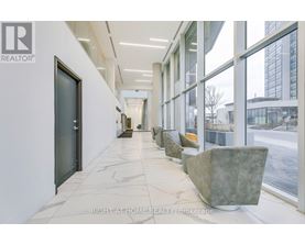 A hallway with marble floors and large windows.