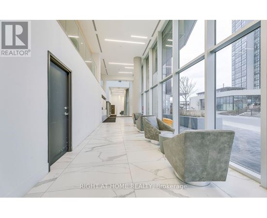 A hallway with marble floors and large windows.