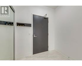 A room with a door and a brokerage sign on the wall.