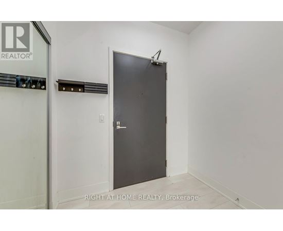 A room with a door and a brokerage sign on the wall.