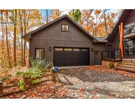 A house with a garage and a driveway covered in leaves.
