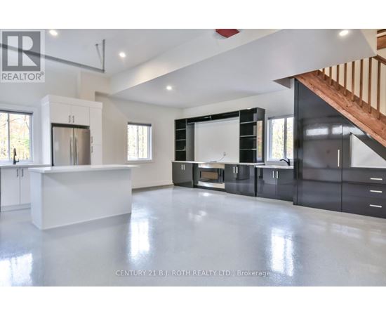 A spacious kitchen with a white countertop and black cabinets.