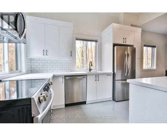 A modern kitchen with white cabinets and stainless steel appliances.