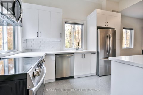 A modern kitchen with white cabinets and stainless steel appliances.