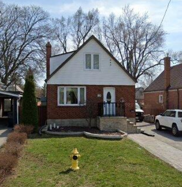 A small house with a yellow fire hydrant in front of it.