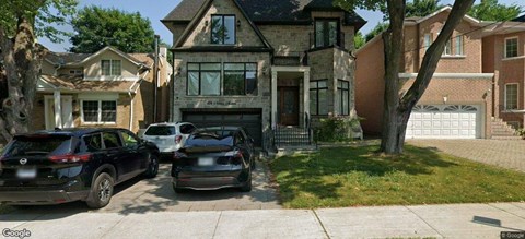 Two black cars parked in front of a house.