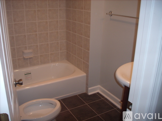A bathroom with a toilet, tub, and towel rack.