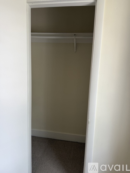 A white closet with a hanger is shown.
