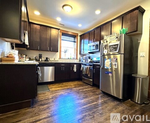 A kitchen with dark wood cabinets and stainless steel appliances.
