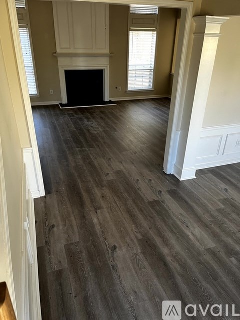 A room with wooden flooring and a fireplace.
