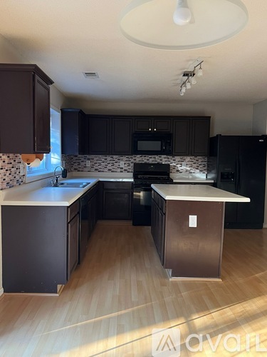 A kitchen with black cabinets and a stainless steel dishwasher.