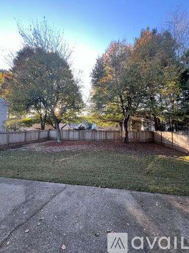 A backyard with a fence and trees.
