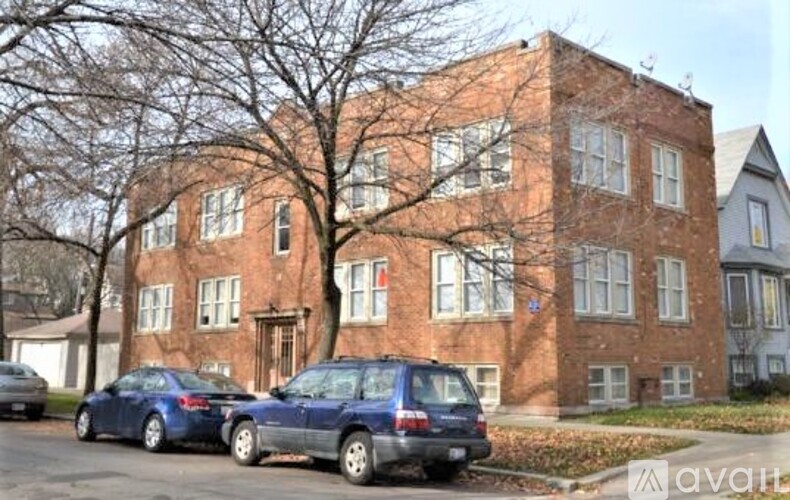 Two cars parked in front of a red brick building.