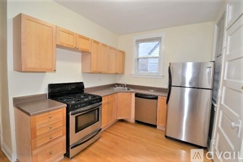 A kitchen with wooden cabinets and a stainless steel refrigerator.