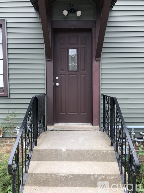 A brown door is at the end of a staircase.