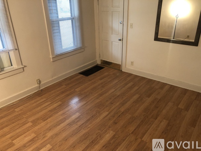 A room with wooden flooring and a white door.