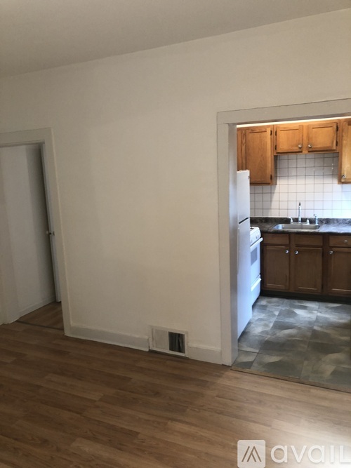 A kitchen with wooden cabinets and a white fridge.