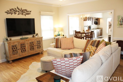 A living room with a white couch and a wooden cabinet.