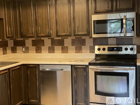 A kitchen with a white counter top and a black oven.