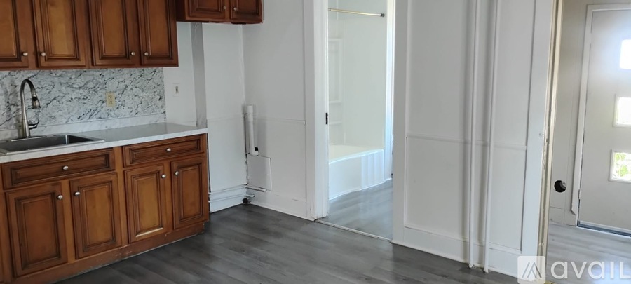 A kitchen with wooden cabinets and a marble backsplash.