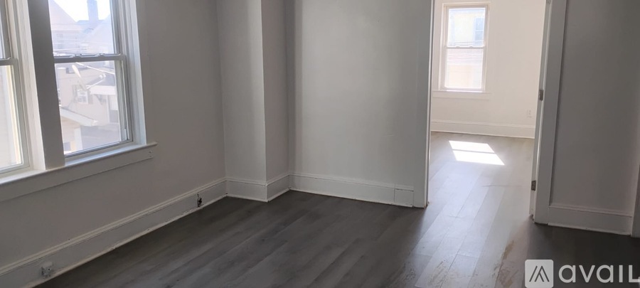 A room with a window and wooden flooring is available for rent or sale.