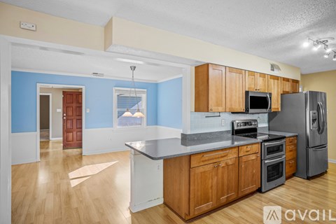 A kitchen with wooden cabinets and a refrigerator.