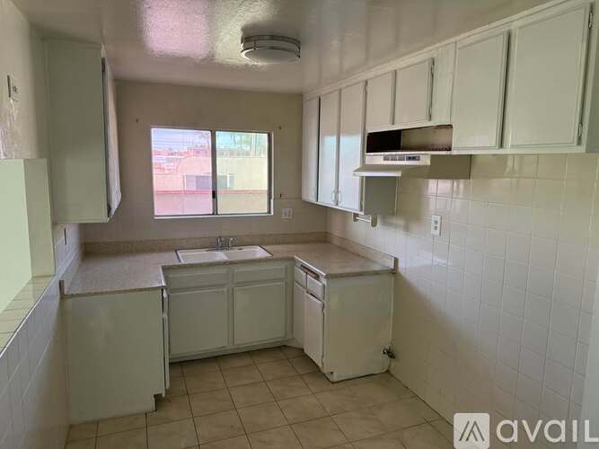 A kitchen with white cabinets and a white dishwasher.