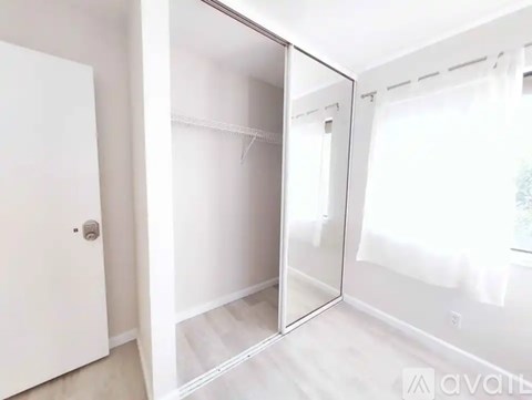A white closet with a mirror door and a white door.