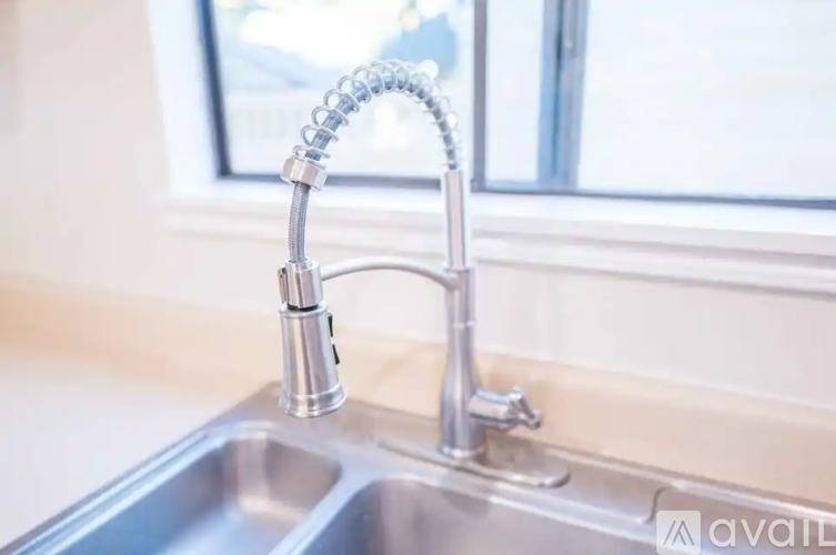 A kitchen sink with a chrome faucet and a pull-down sprayer.