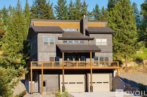 A modern house with a balcony and two garage doors.