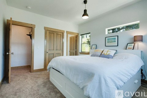 A bedroom with a large bed and a window.