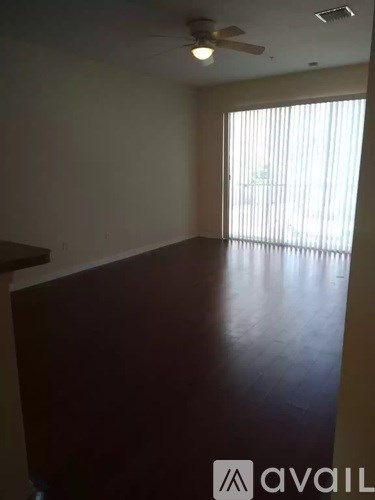 A room with a ceiling fan and a window with blinds.