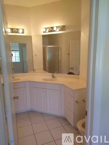 A bathroom with a white counter and a toilet in the corner.