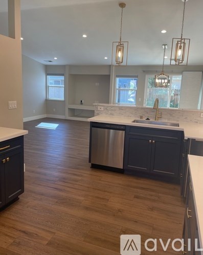 A kitchen with dark wood floors and a white countertop.