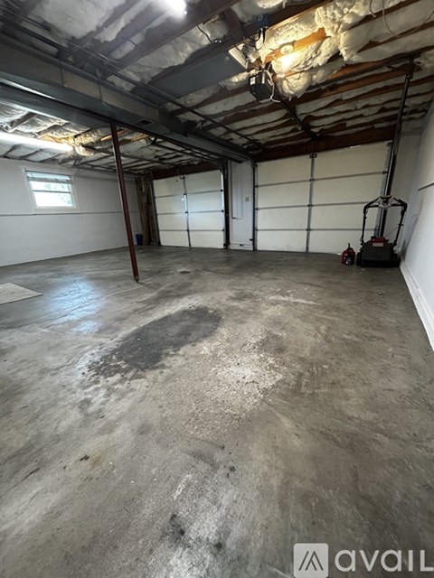 A large empty room with a concrete floor and a window.