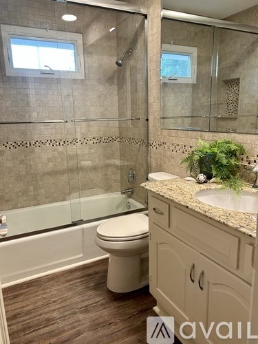 A bathroom with a toilet, sink, and shower.