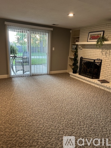 A living room with a fireplace and a sliding glass door.