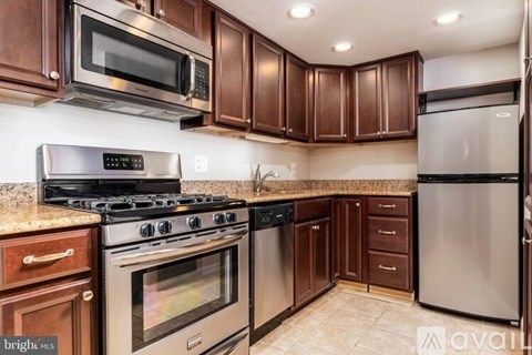 A kitchen with brown cabinets and stainless steel appliances.