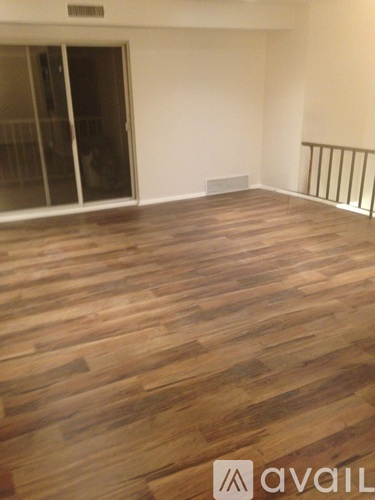 A room with wooden flooring and a glass door.