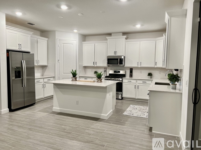 A modern kitchen with white cabinets and a central island.