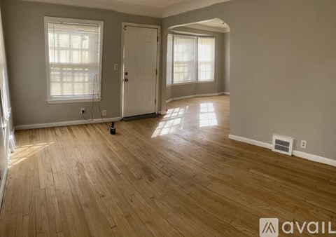 A room with wooden flooring and a white door.
