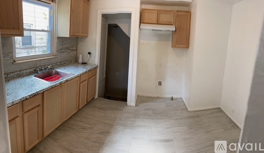 A kitchen with wooden cabinets and a marble countertop.