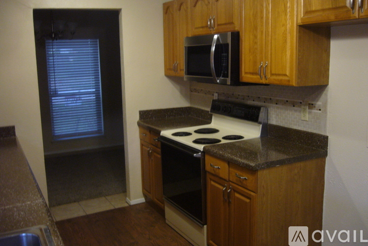 A kitchen with wooden cabinets and a black stove top.