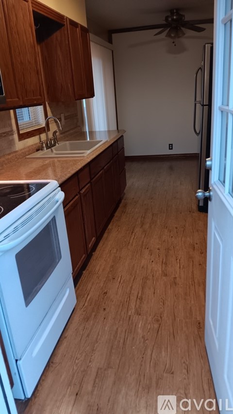 A kitchen with wooden cabinets and a white oven.
