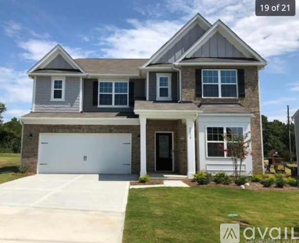 A two-story house with a garage is available for sale.