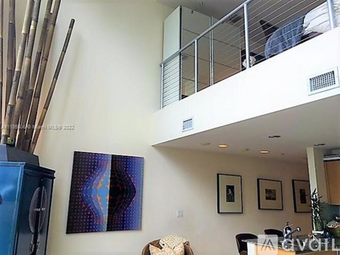 A living room with a blue cabinet and a painting on the wall.