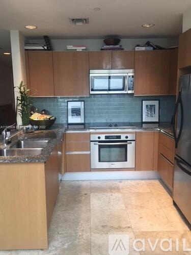 A kitchen with wooden cabinets and a granite countertop.