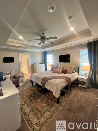 A bedroom with a large bed and a ceiling fan.