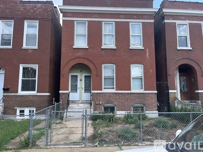 A red brick building with a white door and windows.